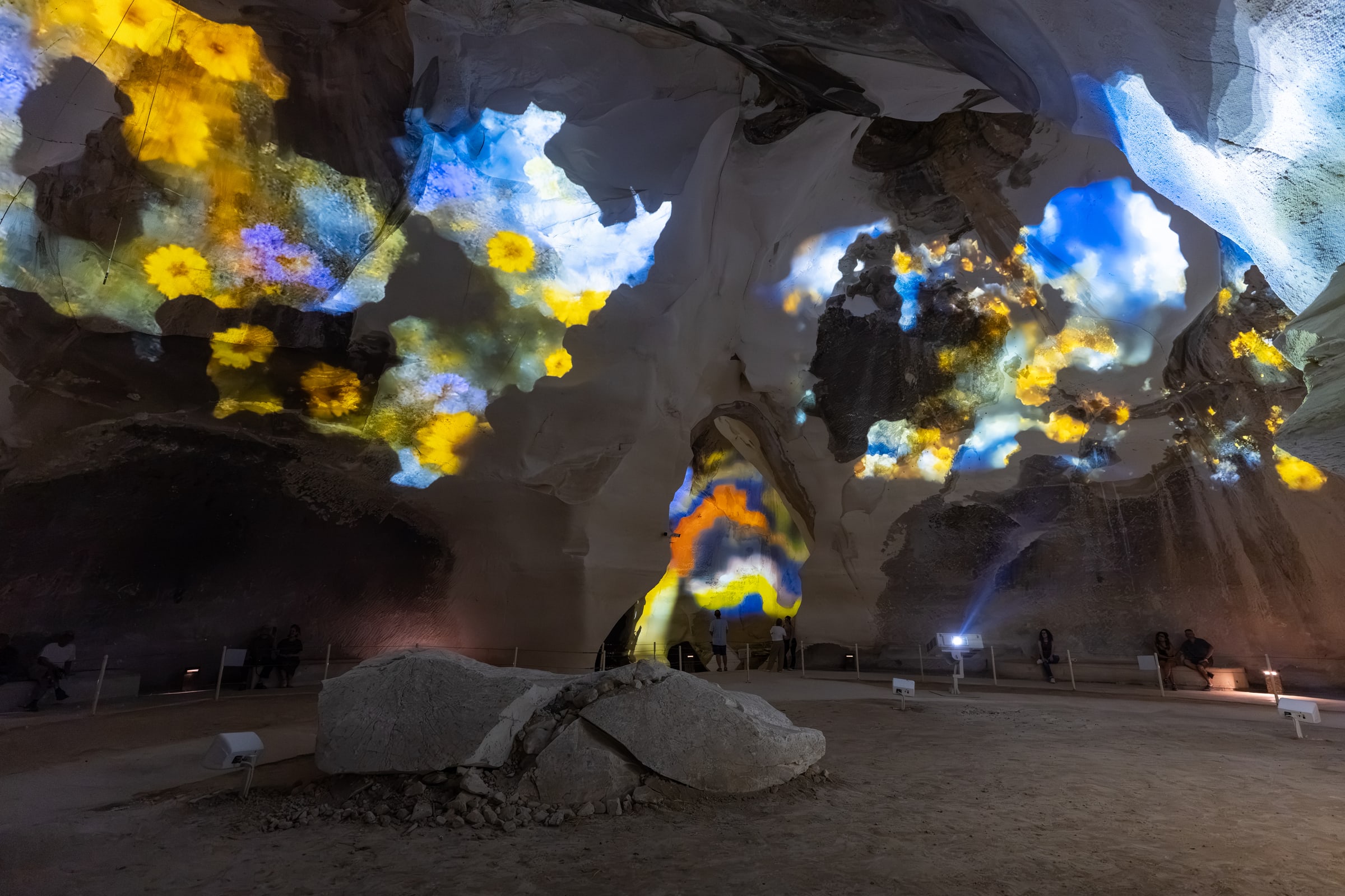 Blue, yellow and white floral projections spread across the curved stone walls of The Eighth Sound installation.